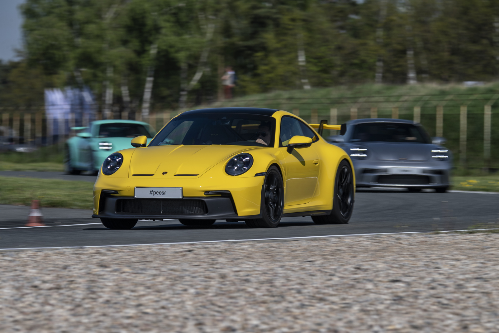 Dwa samochody marki Porsche na torze wyścigowym
